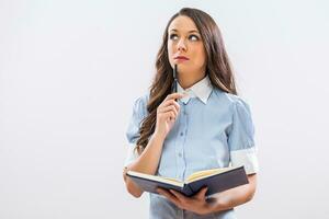 Pensive businesswoman holding her personal organizer and thinking photo