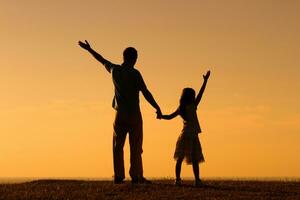 padre y hija saludo el puesta de sol foto