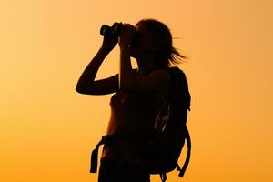 Woman hiker with binoculars photo