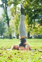 hermosa mujer hacer ejercicio yoga al aire libre foto