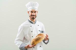 Baker holding bread on gray background photo