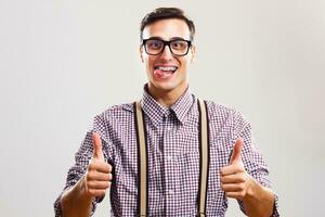 Nerdy man giving thumb up and sticking out tongue photo