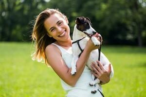 Beautiful woman enjoys spending time in the nature with her cute dog Jack Russell Terrier. photo