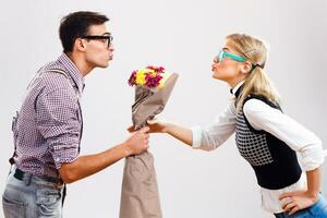 Nerdy man is giving flowers to his nerdy lady photo