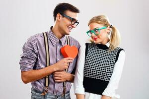 nerd hombre es dando corazón forma caja a su nerd Novia foto