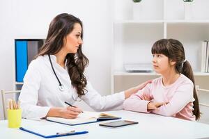 hembra médico y niño hablando a el médico oficina foto