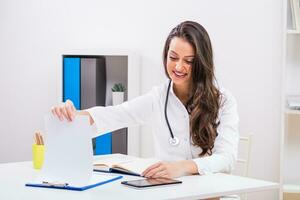 Beautiful female doctor working at her office photo