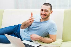 Young man using laptop at his home photo