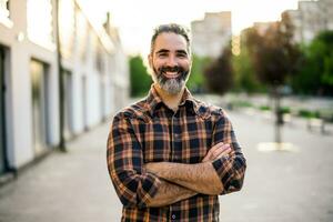 retrato de moderno empresario con barba en pie en el ciudad calle foto