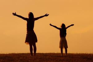 Mother and daughter greeting the sunset photo