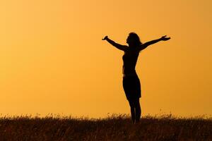 Silhouette of a  woman with her arms  outstretched photo