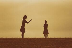 Silhouette of a angry mother scolding her daughter photo