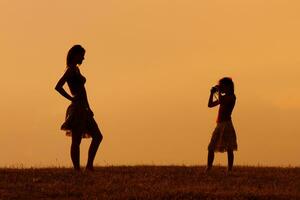 Silhouette of a daughter photographing mother photo
