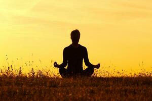 Silhouette of woman doing yoga photo