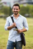 Young businessman is using digital tablet at the park photo