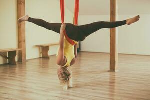 mujer haciendo aéreo yoga en el aptitud estudio foto