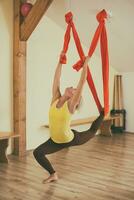 Woman doing aerial yoga in the fitness studio photo