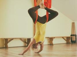 Woman doing aerial yoga in the fitness studio photo