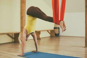 Woman doing aerial yoga in the fitness studio photo