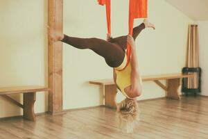 Woman doing aerial yoga in the fitness studio photo