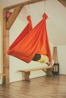 Woman doing aerial yoga in the fitness studio photo