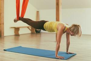 Woman doing aerial yoga in the fitness studio photo