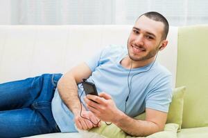 Young man is listening music from his mobile phone photo