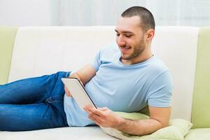 Young man using digital tablet at his home photo