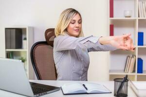 Businesswoman stretching while working in her office photo