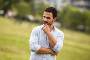 Worried businessman is standing at the park and thinking about something photo