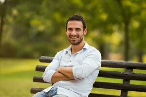 joven empresario disfruta sentado a el parque foto