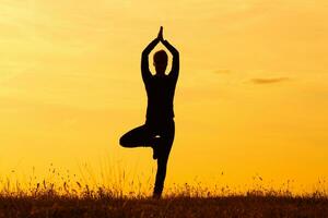 Silhouette of woman doing yoga photo