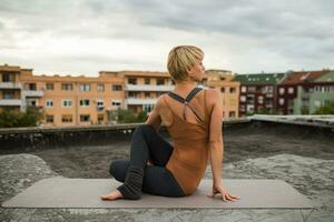 Woman practicing yoga on the roof photo