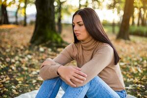 Sad woman sitting alone in the park photo