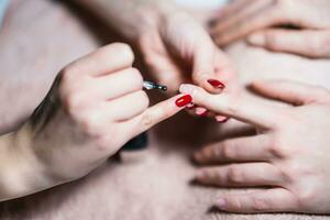 cerca arriba imagen de manicura proceso, manicuro aplicando gel uña polaco en hembra uñas atención en uña. foto