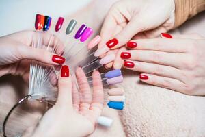 Close up image of manicurist showing  color palette of nail services. Focus on part of palette. photo