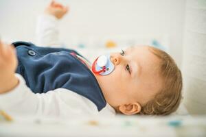 Close up portrait of cute baby boy with pacifier photo