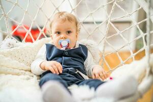 Image of cute baby boy with pacifier sitting photo