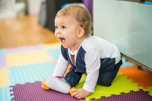 Image of cute baby boy crawling on the floor photo