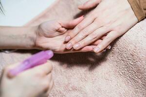 Close up image of manicure process ,manicurist spraying with water female fingernails. Focus on nails. photo