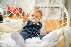 Image of cute baby boy with pacifier sitting photo