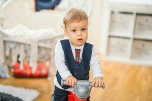 Image of cute little baby boy riding his first bike photo