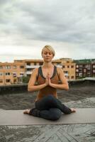 Woman practicing yoga on the roof photo