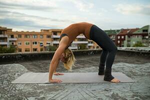 mujer practicando yoga en el techo foto