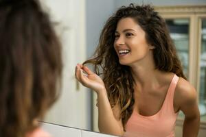 Beautiful woman  is playing with her long curly hair  in the bathroom photo