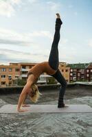 Woman practicing yoga on the roof photo