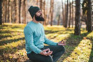 Sporty man enjoys meditating in the nature photo