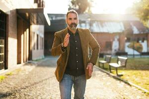 Modern businessman with beard running in a hurry on the street photo