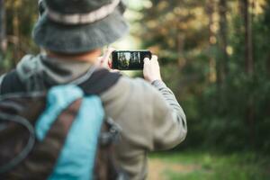 imagen de hombre disfruta excursionismo y haciendo imágenes con su teléfono foto