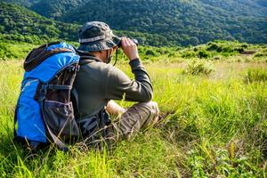 Image of man hiking and using binoculars photo